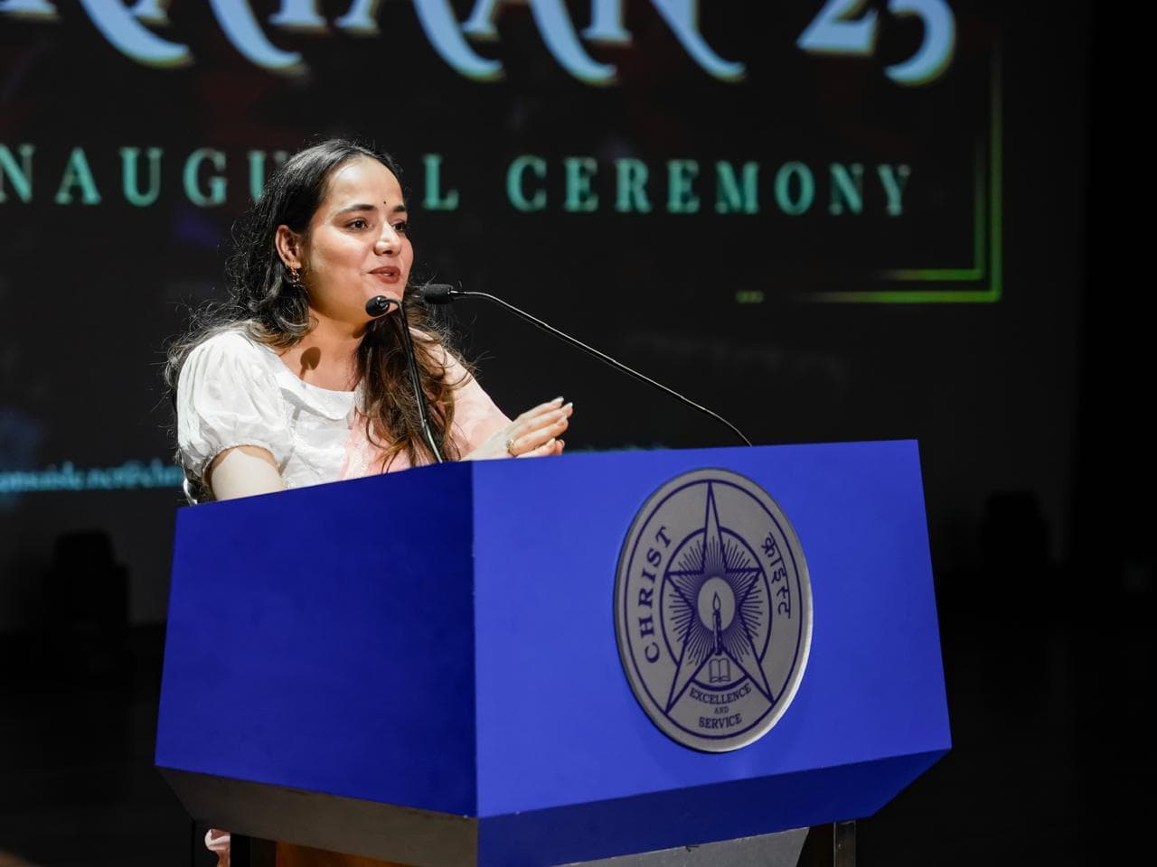 Gunjan Singh speaking at the podium, Prayaan '25 inaugural ceremony